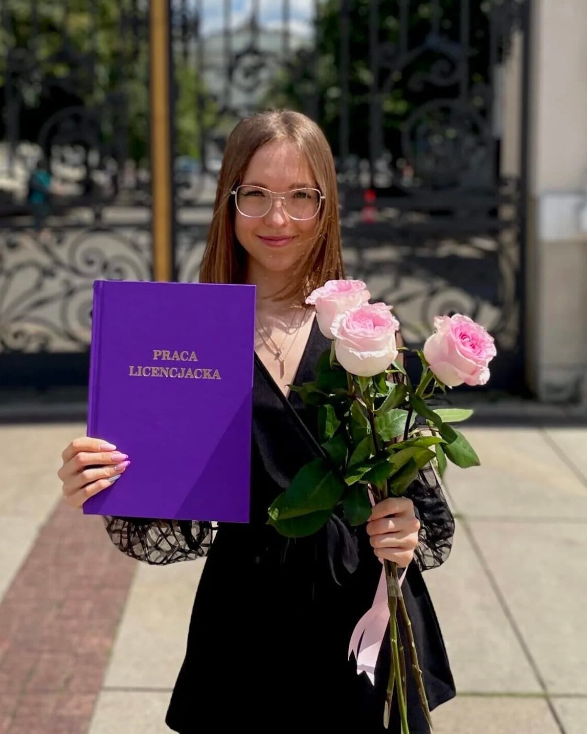 Kinga z pracą licencjacką przed bramą Uniwersytetu Warszawskiego