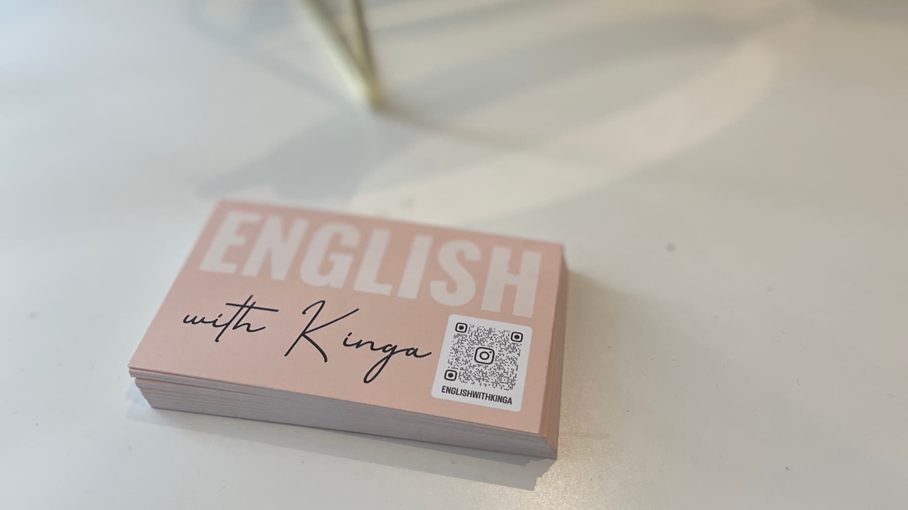 Stos wizytówek English with Kinga na białym biurku